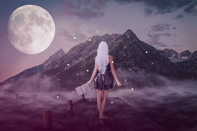 Girl seen from the back, holding an open book, on a background of purple mountains and full moon