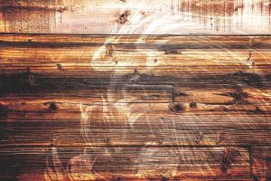 A very faint image of a fallen angel, etched in wood