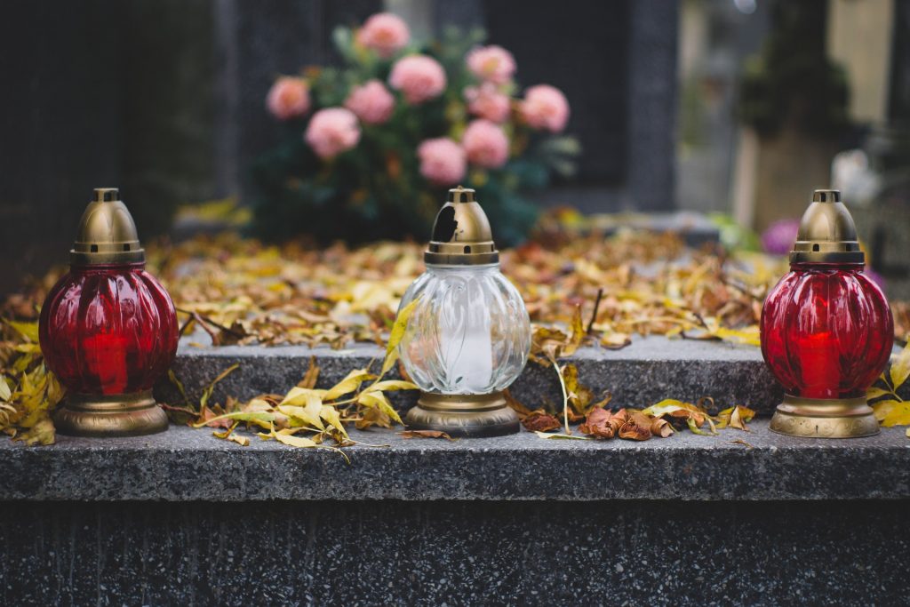 a grave with flowers and lit candles